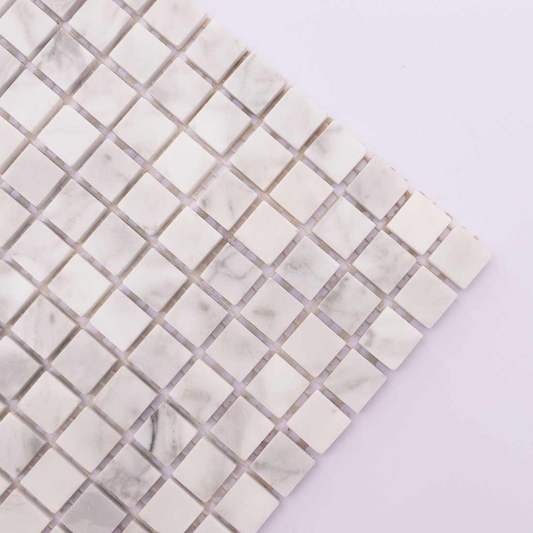 Corner detail of Carrara white square marble mosaic tile with gray veining