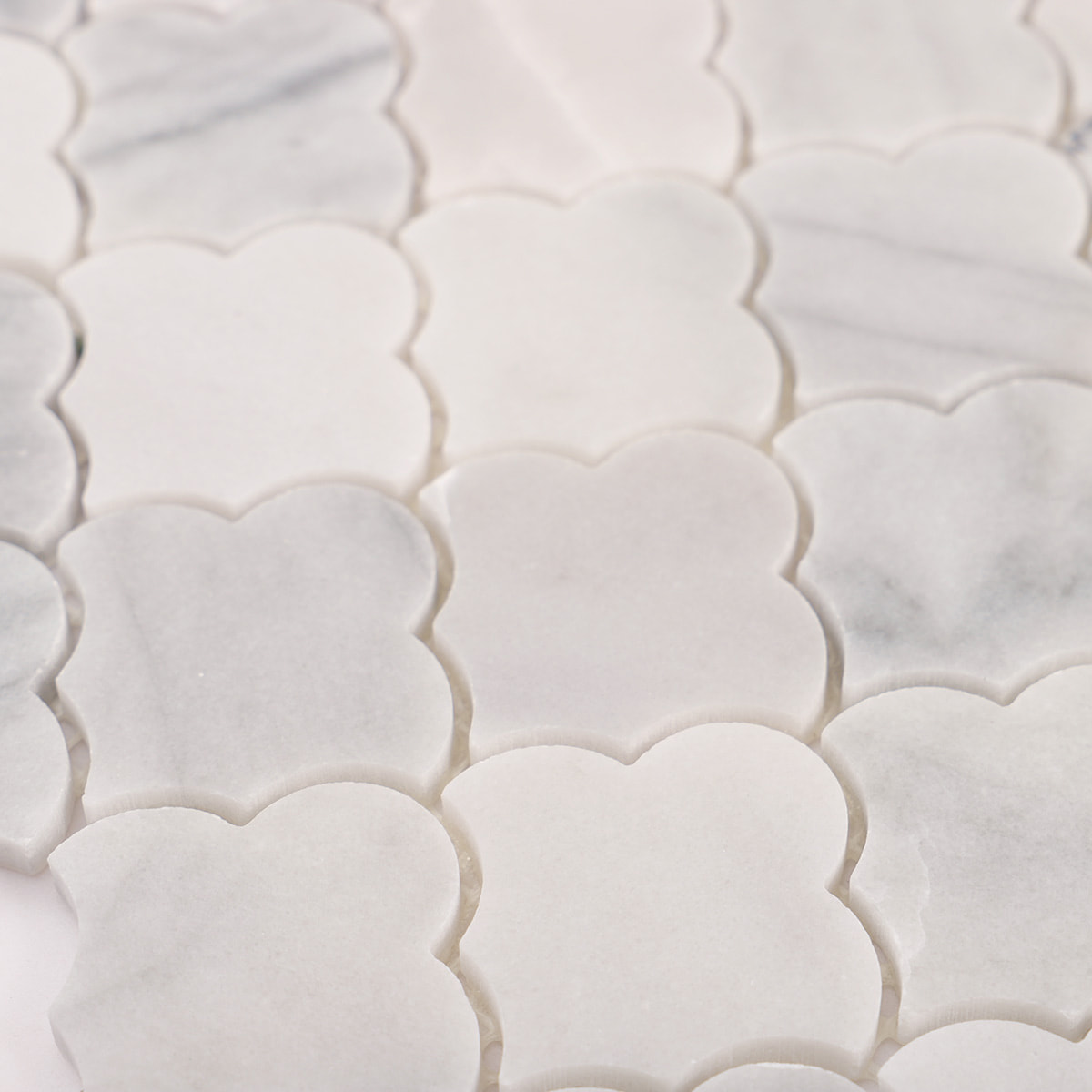 Surface detail of Carrara white cloud marble mosaic with natural veining