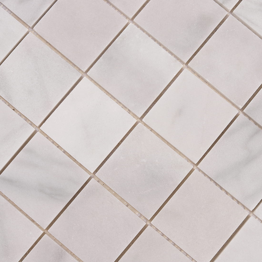 Detailed look at Carrara white marble veining on large square mosaic tiles