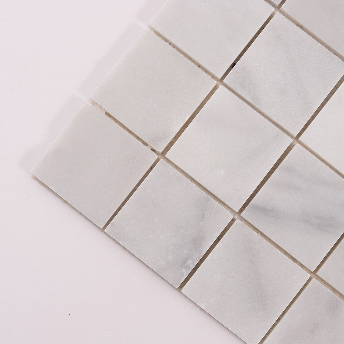 Close up of Carrara white large square marble mosaic tiles at sheet corner