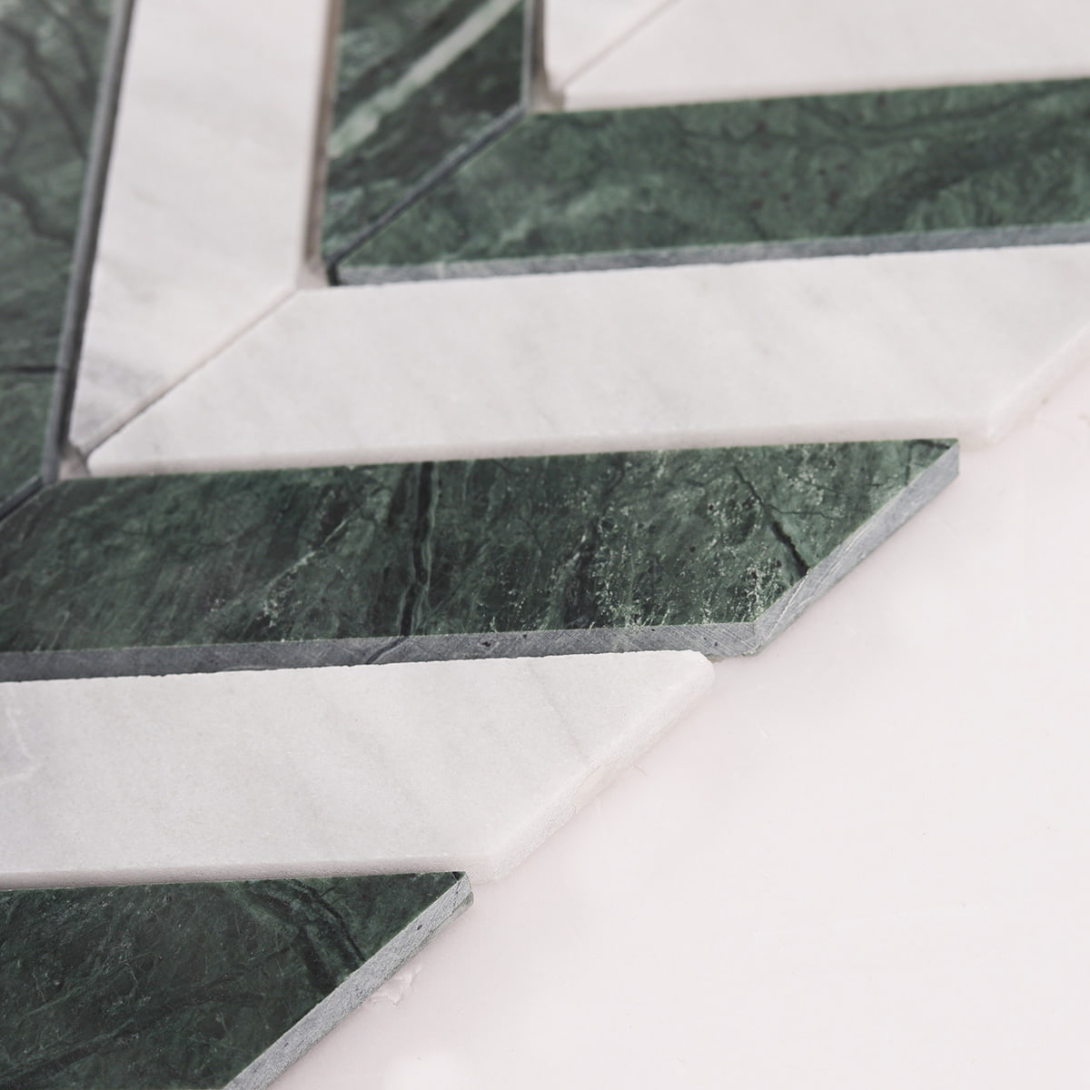 Angled view showing thickness of green and white chevron marble mosaic