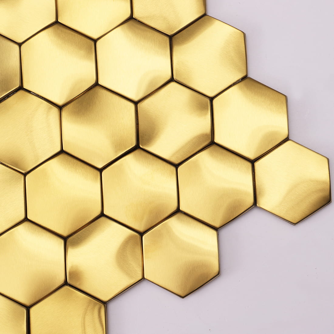 Close-up detail showing the 3D surface and edges of gold hexagon metal tiles.