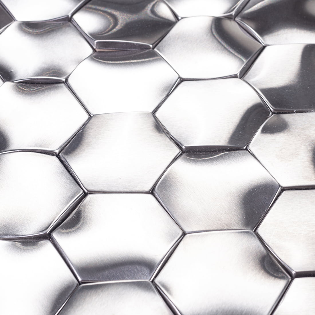 Close-up of 3D silver hexagon metal tiles showing brushed texture and reflections.
