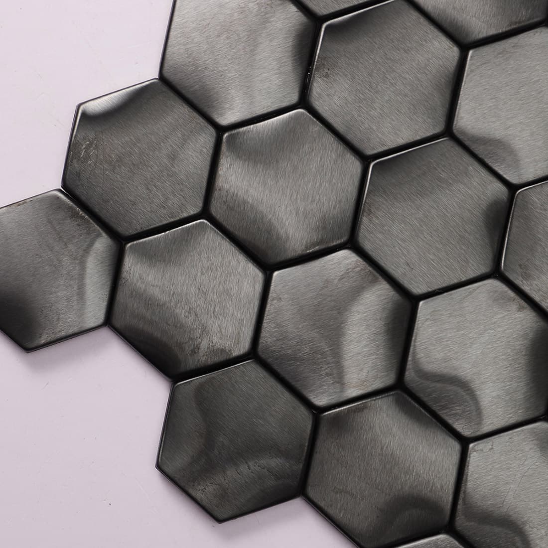 Close-up view of the corner of a black hexagon metal mosaic tile sheet.