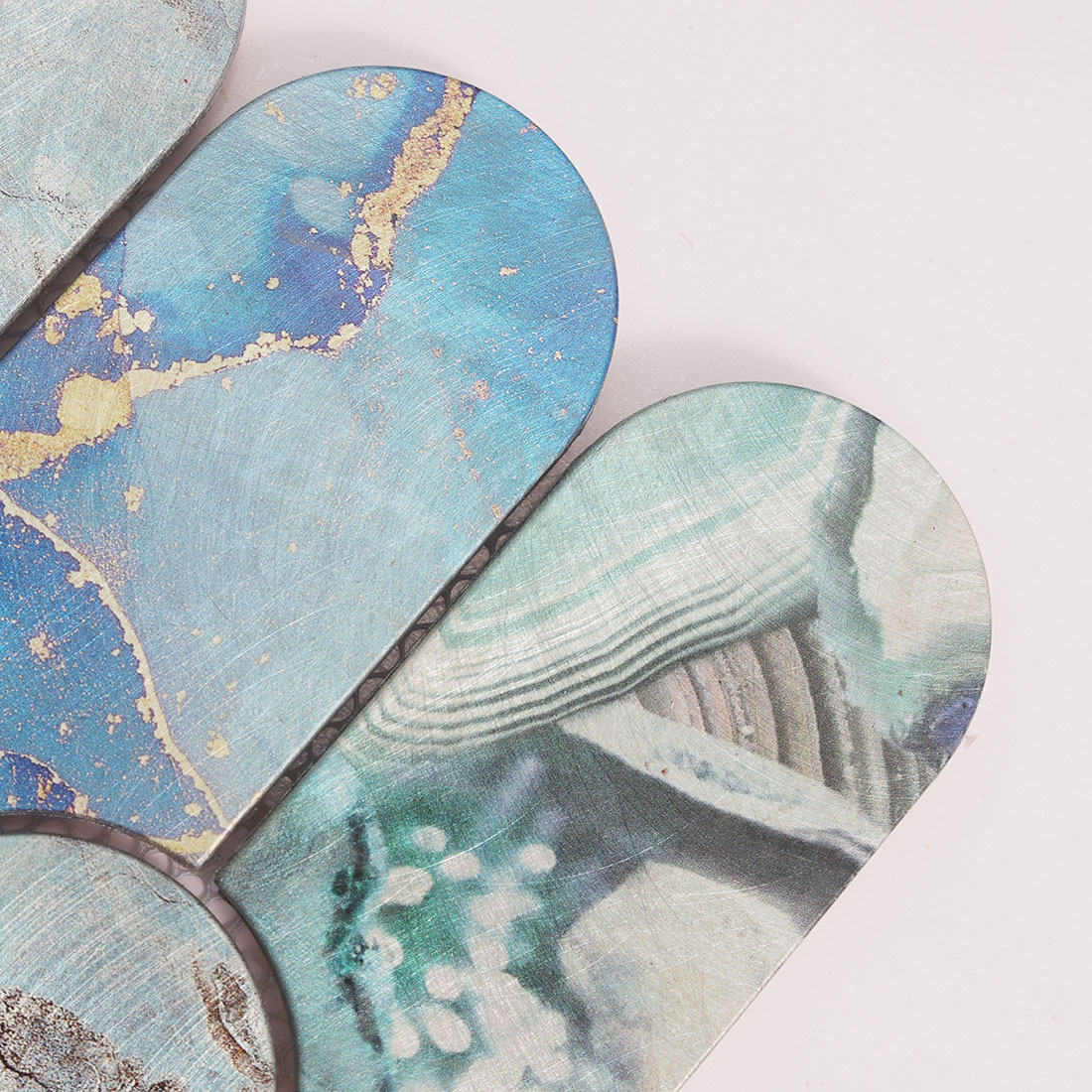 Close-up of blue rounded arch aluminum mosaic tile with brushed texture
