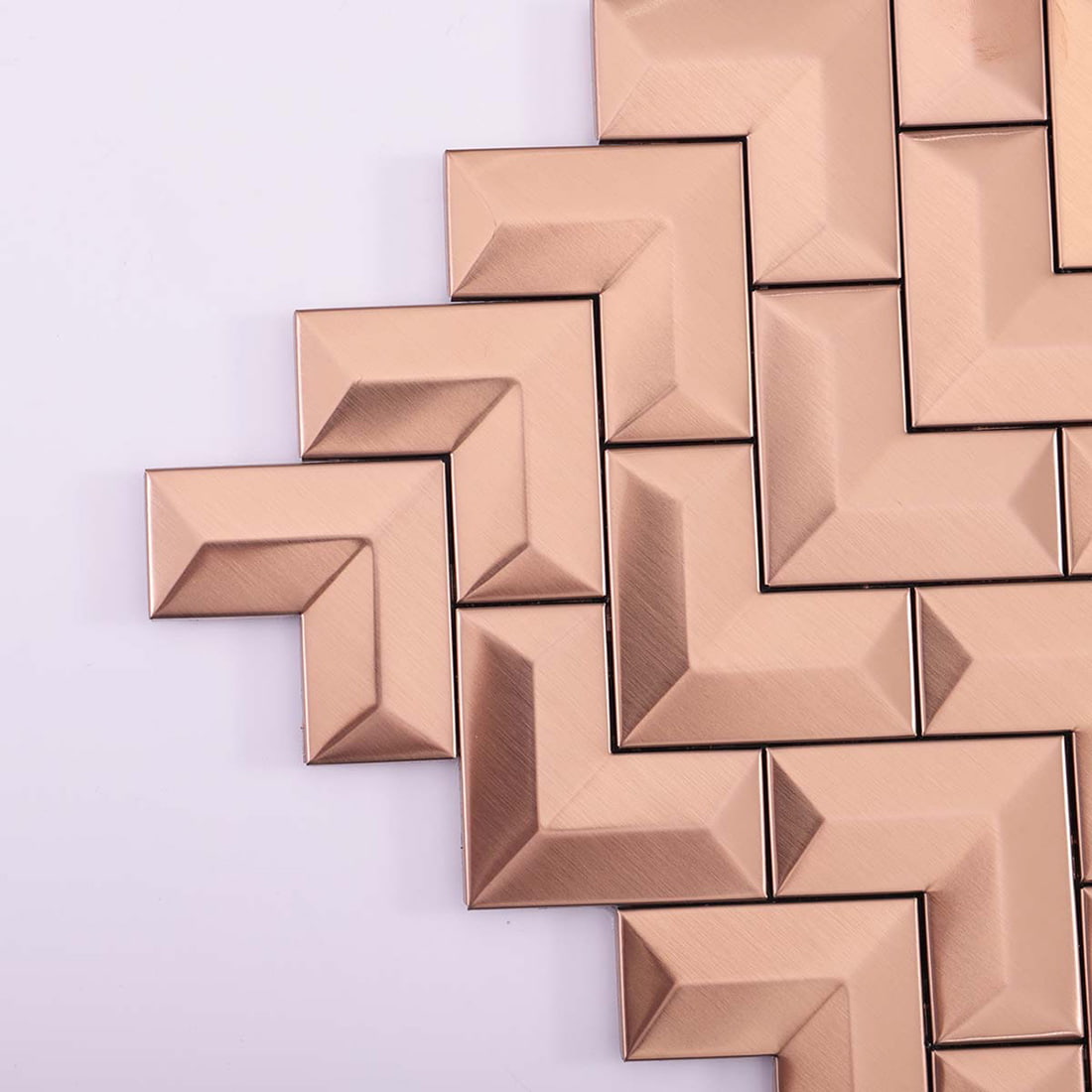 Detailed close-up of the edges of brushed rose gold chevron metal tiles.