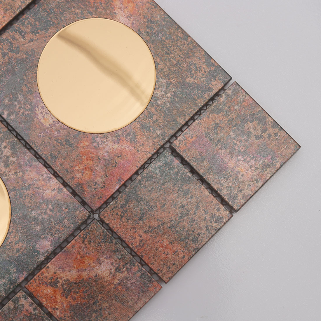 Close-up of copper aluminum mosaic tile with round mirror glass insert