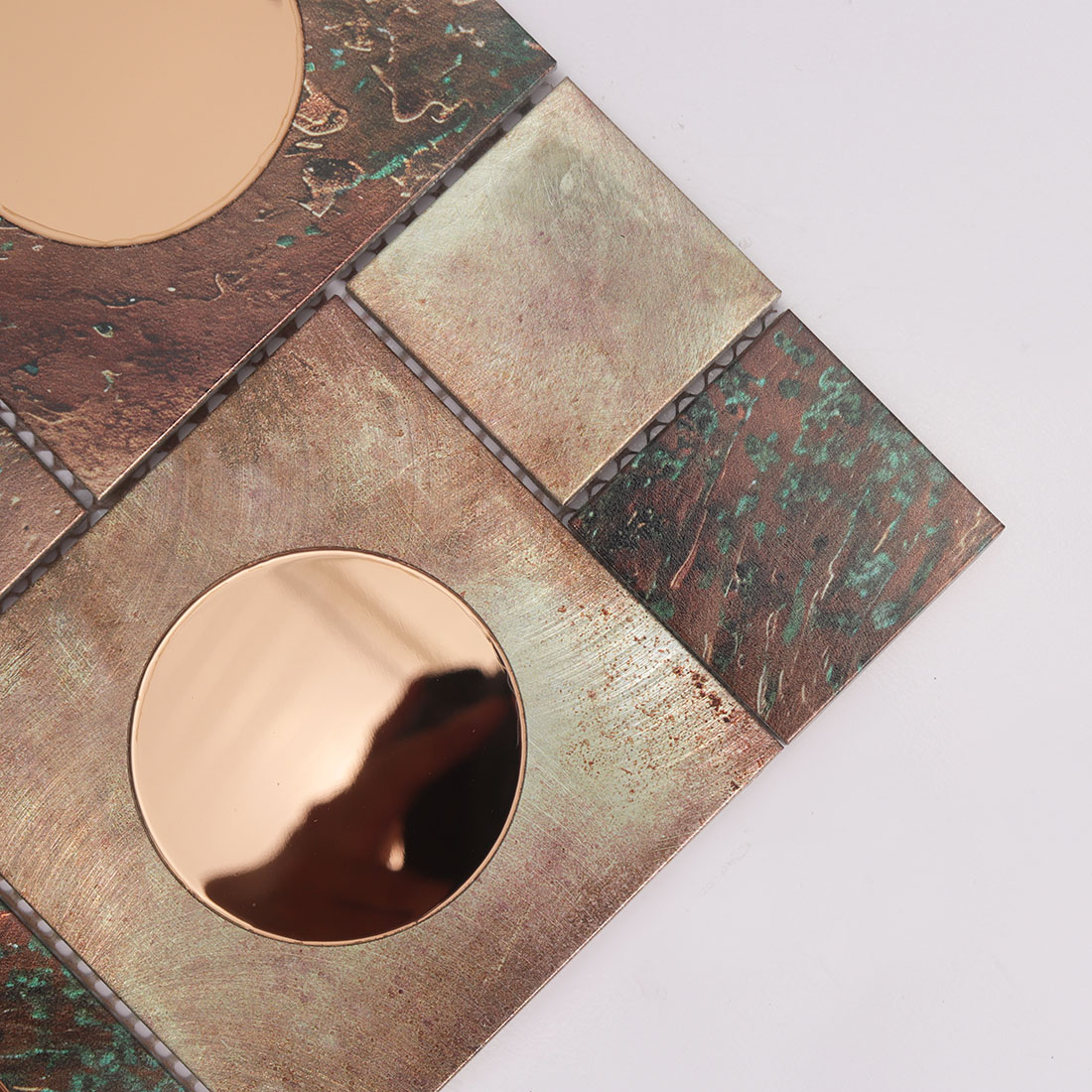Close-up of rose gold round mirror glass on copper aluminum mosaic tile