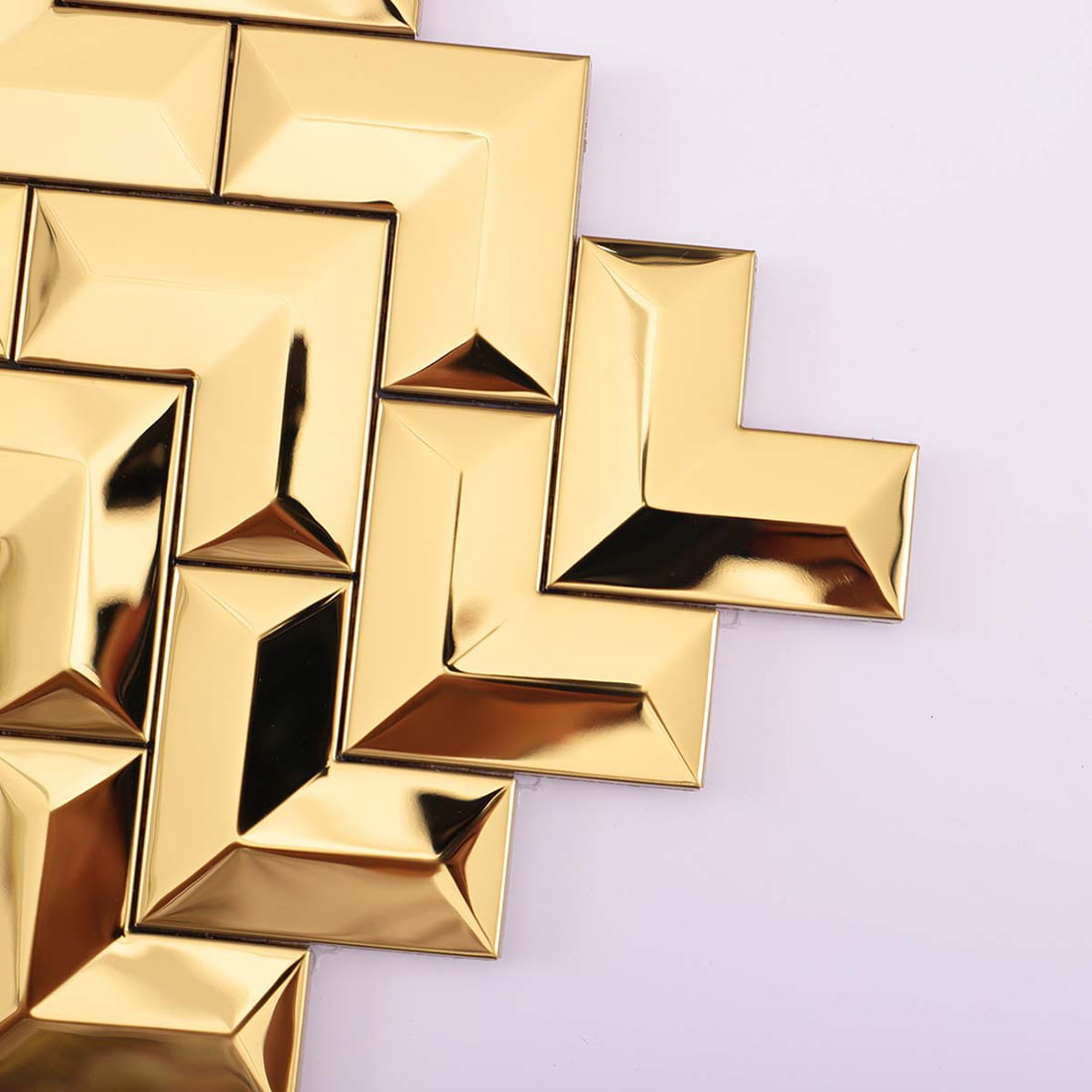 Close-up detail of the edges and corners of gold chevron metal tiles.