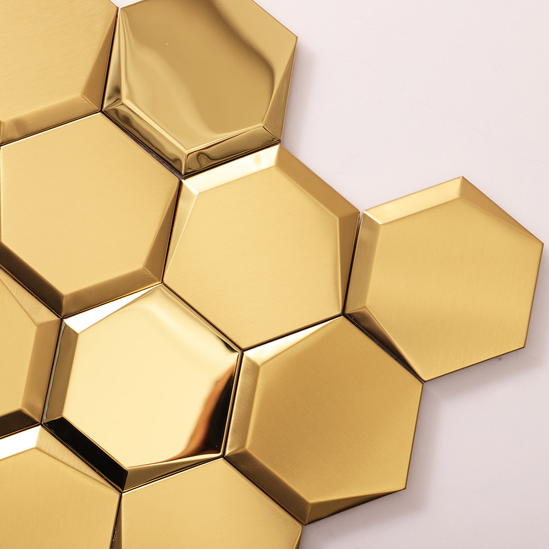 Macro shot of gold hexagon tiles showing beveled edges and metallic finishes.