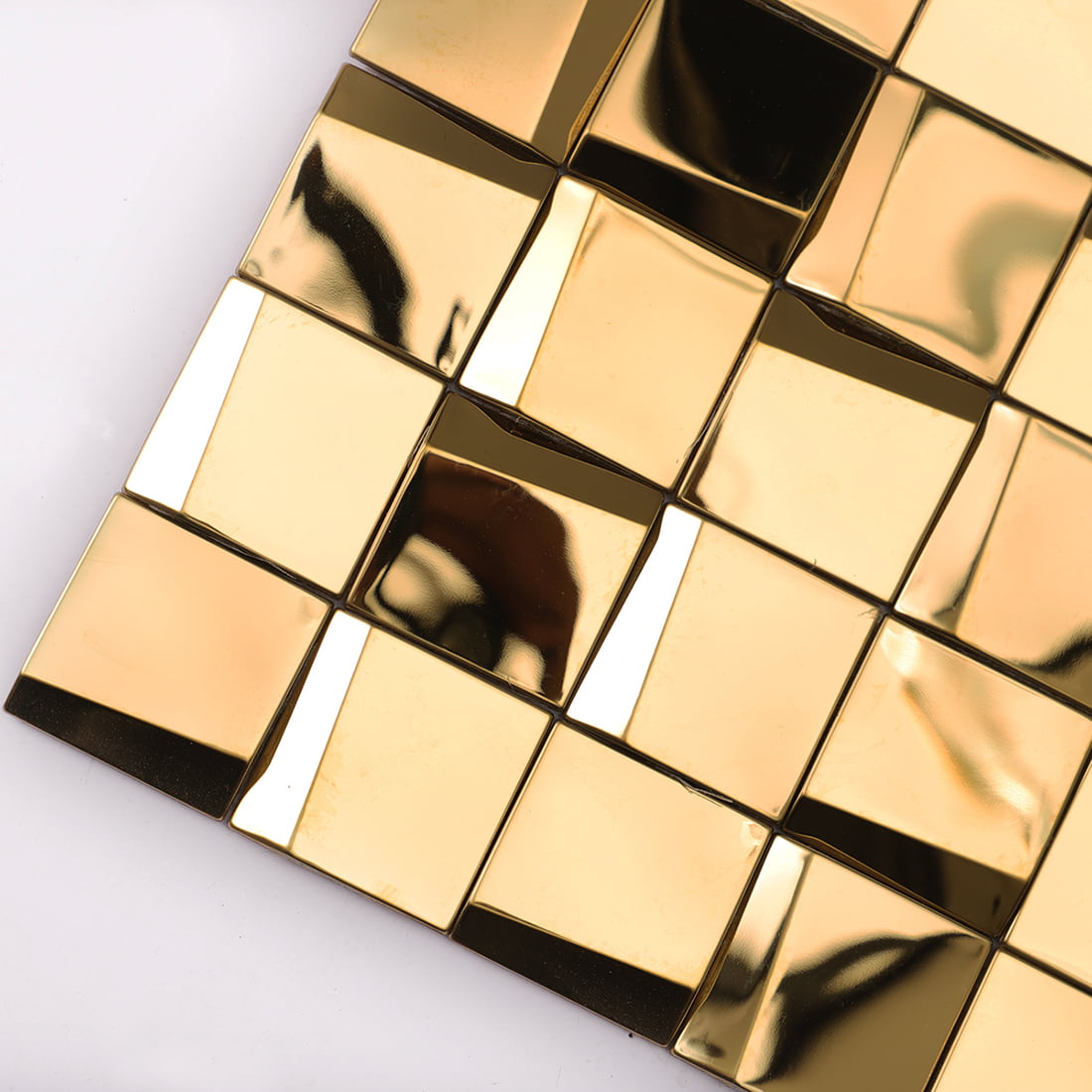 Close-up of gold reflective 3D square mosaic tiles showing bright metallic facets.