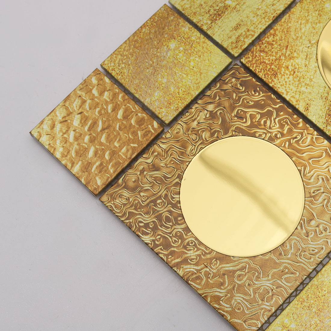 Close-up of gold round glass on textured gold metal mosaic tile