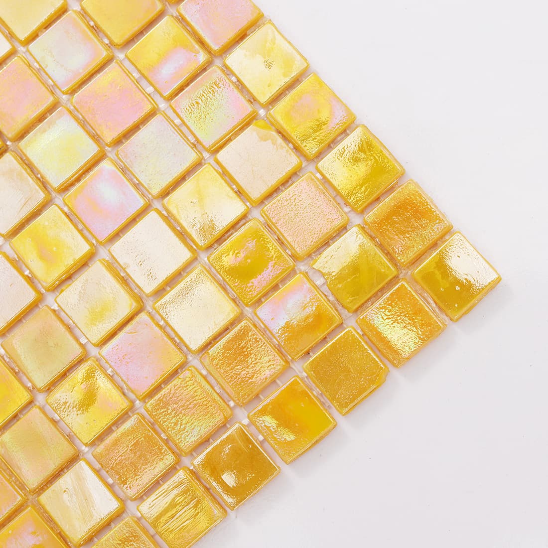 Close-up of iridescent yellow glass mosaic tiles with glossy reflective surface