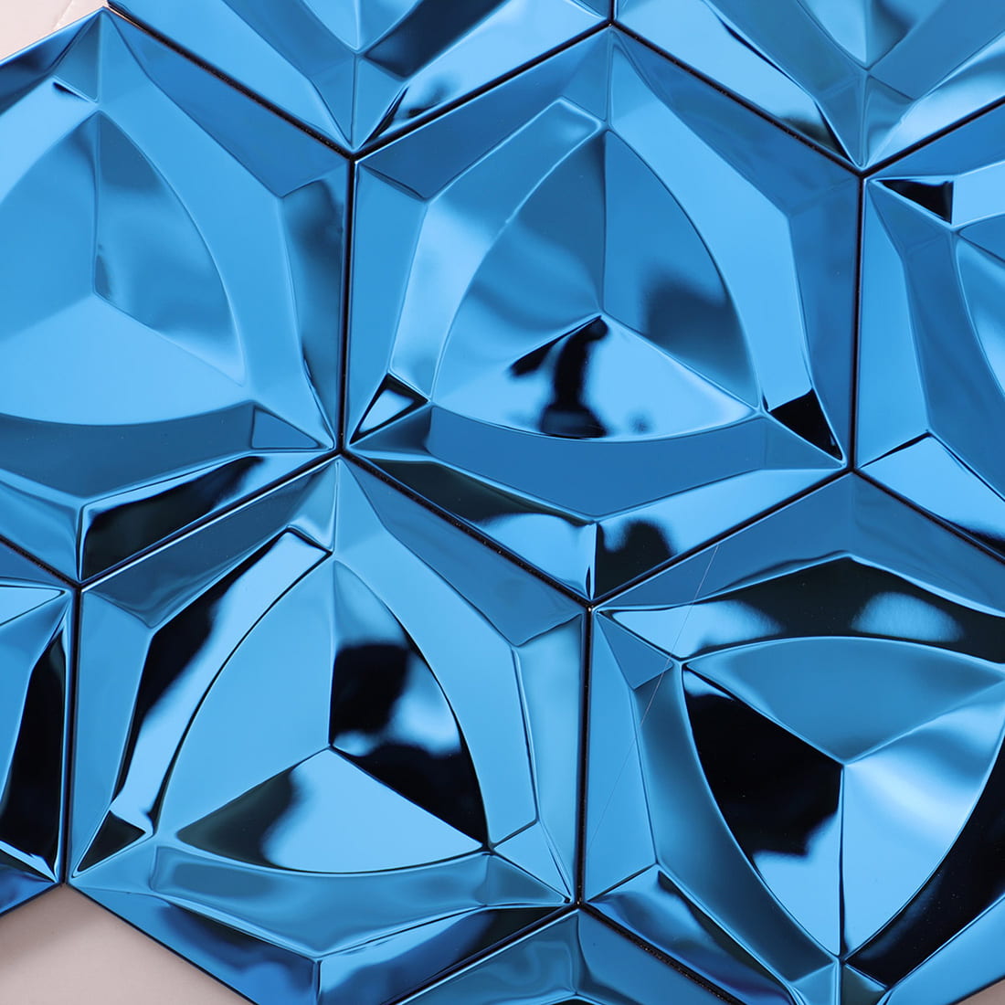 Close-up of reflective blue 3D geometric hexagon tiles with metallic finish.