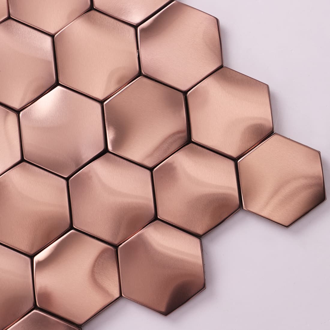 Close-up detail showing the wavy 3D surface of rose gold hexagon tiles.