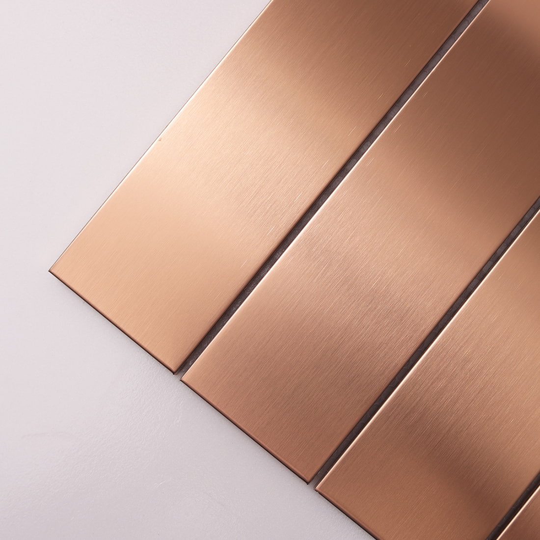 Close-up showing the brushed texture on rose gold metal tile strips.