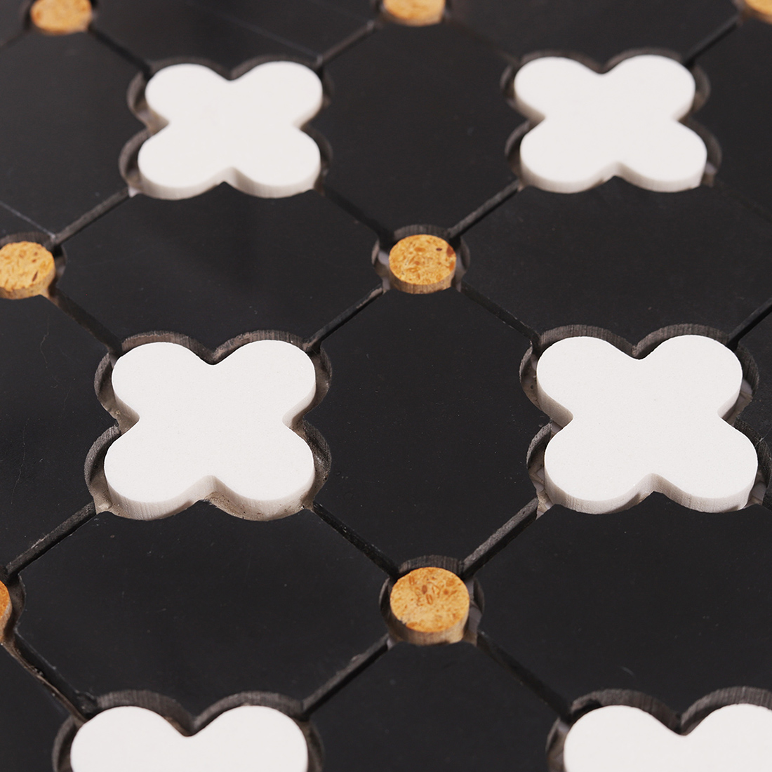 Macro view showing raised white clover pieces on black marble mosaic