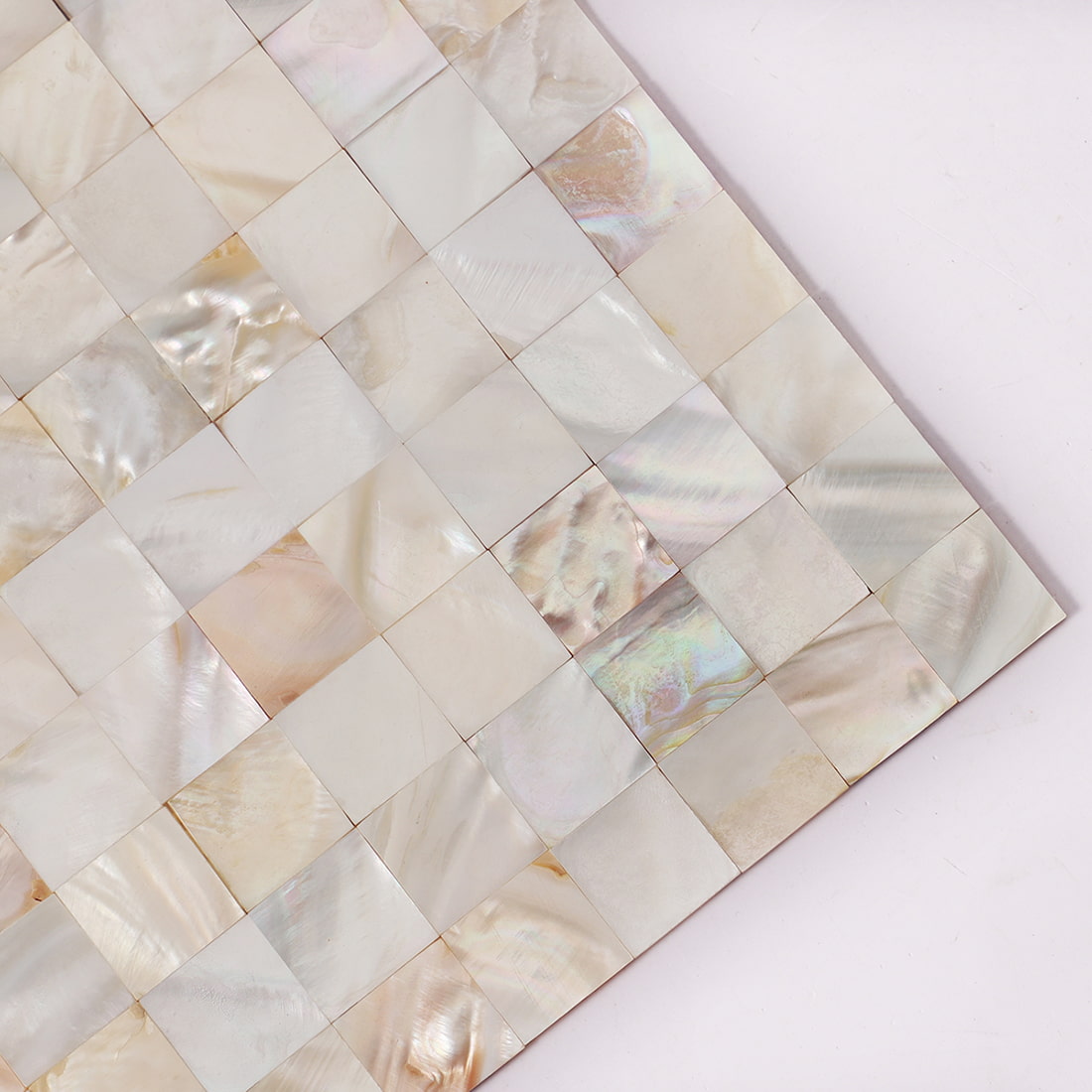 Close up corner of cream white mother of pearl square mosaic tile sheet