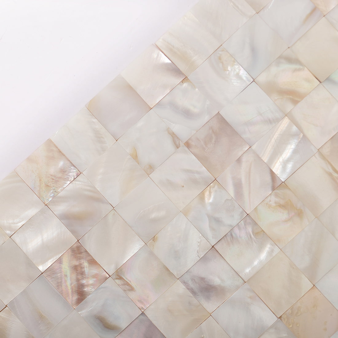 Diagonal close up of cream white mother of pearl square mosaic pattern
