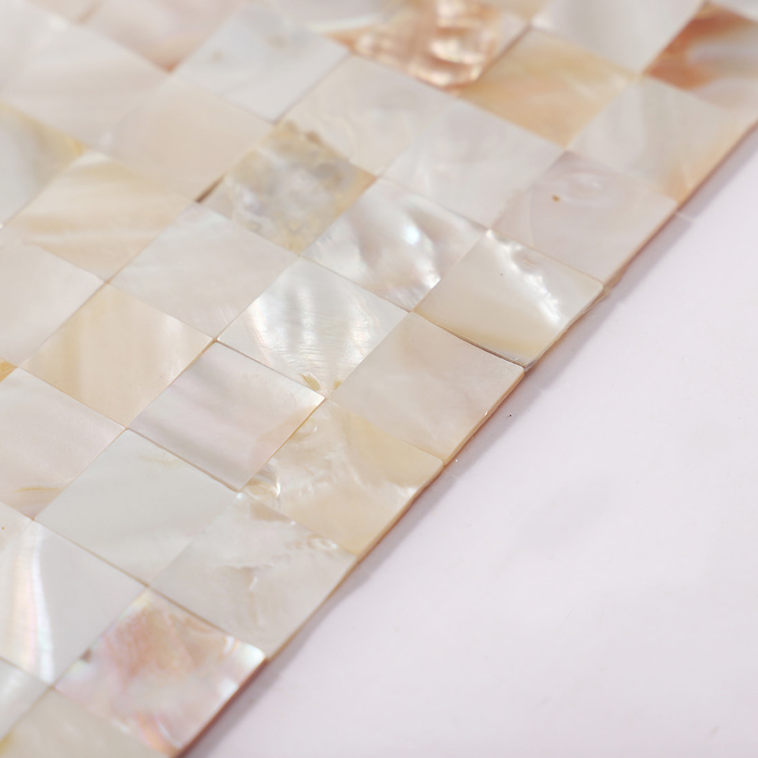 Edge detail of cream white mother of pearl mosaic sheet with square chips