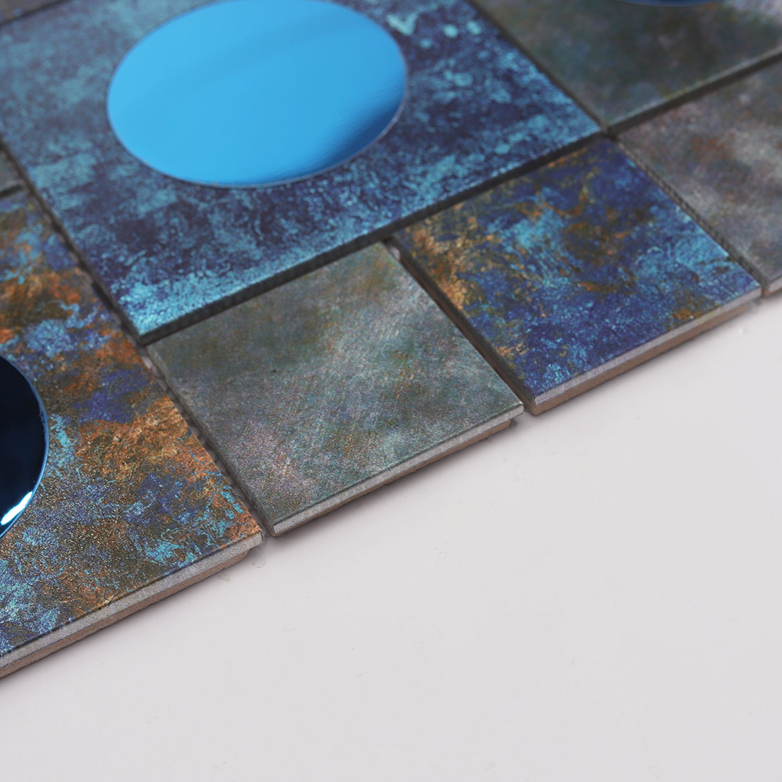 Edge detail of dark blue aluminum mosaic tile with metallic textured finish