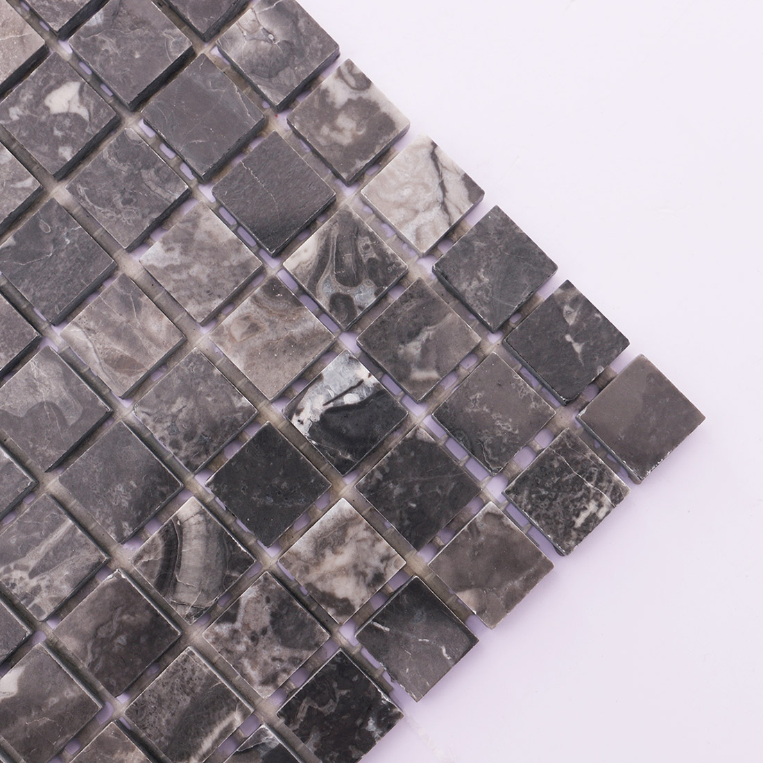 Corner detail of dark gray square marble mosaic tile with white veining