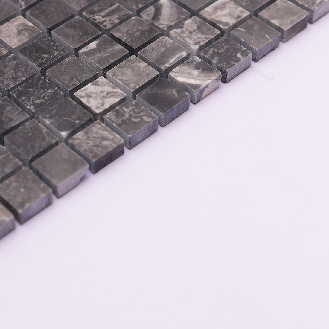 Side edge of dark gray square marble mosaic tile with natural veining