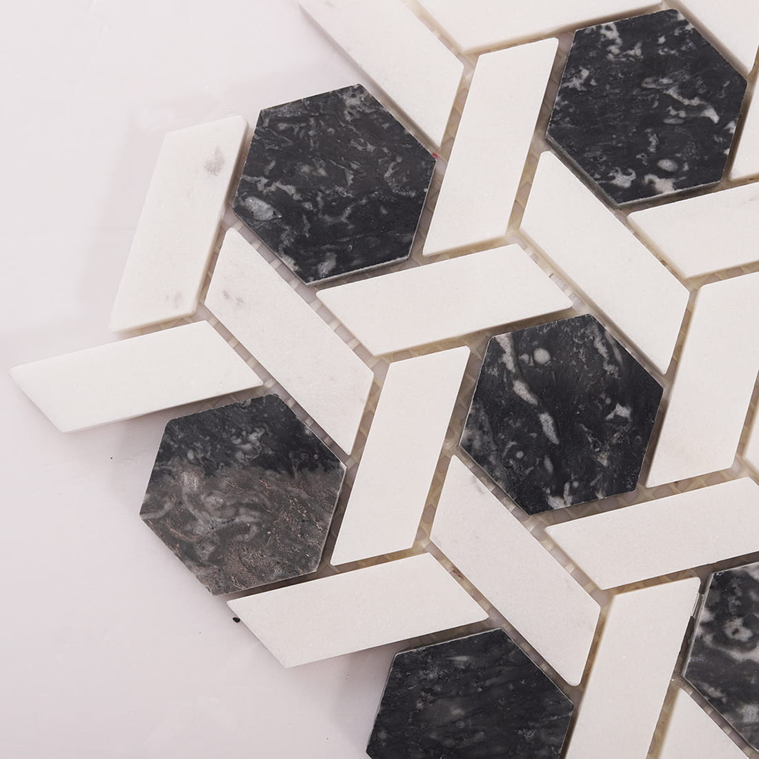 Corner close-up of dark grey marble hexagon mosaic with grout joints