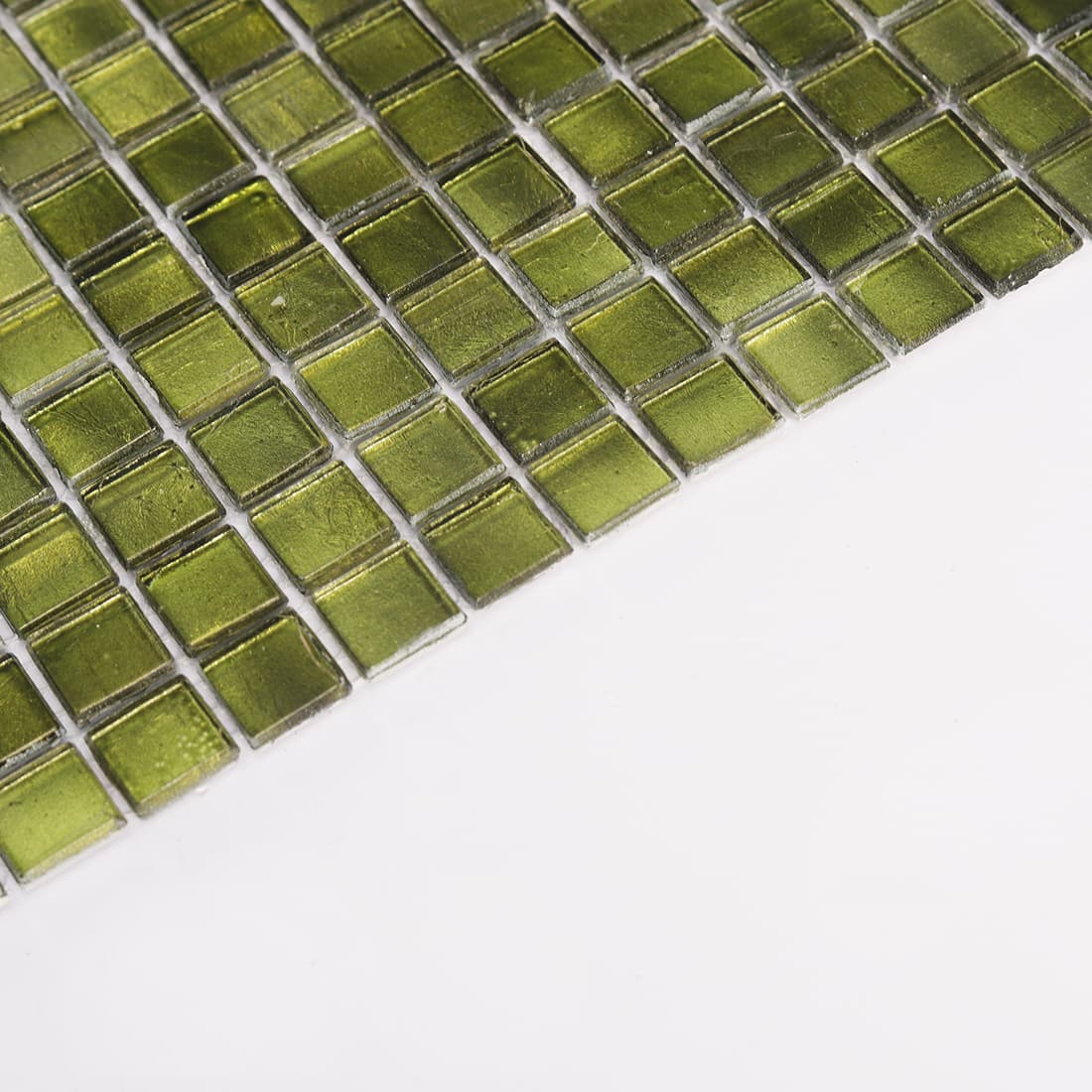 Close up edge view of dark olive green glass mosaic tiles with reflective finish