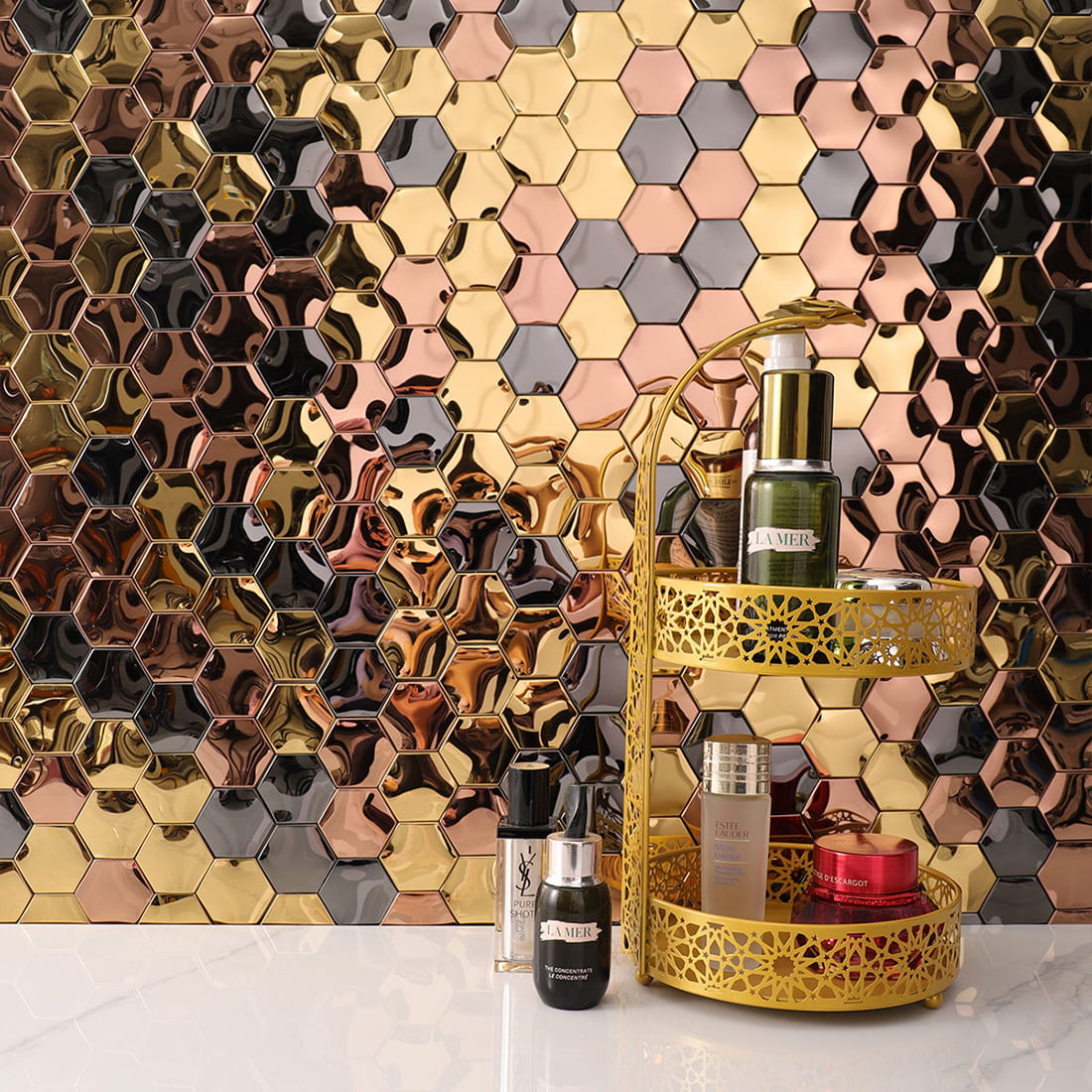 Full view of a reflective metallic mosaic wall behind luxury skincare products.