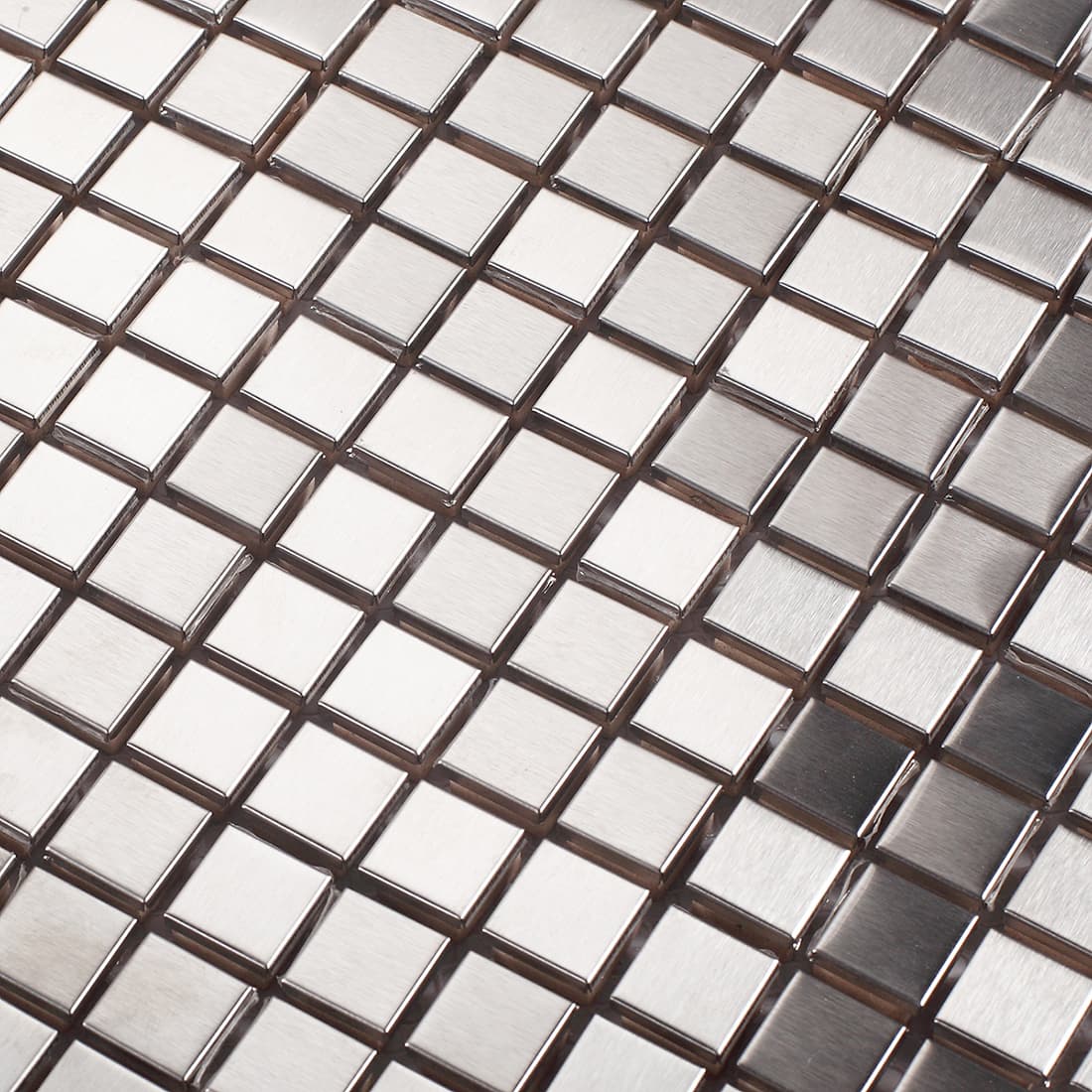 Detailed macro view of brushed silver stainless steel square mosaic tiles with reflective surfaces.