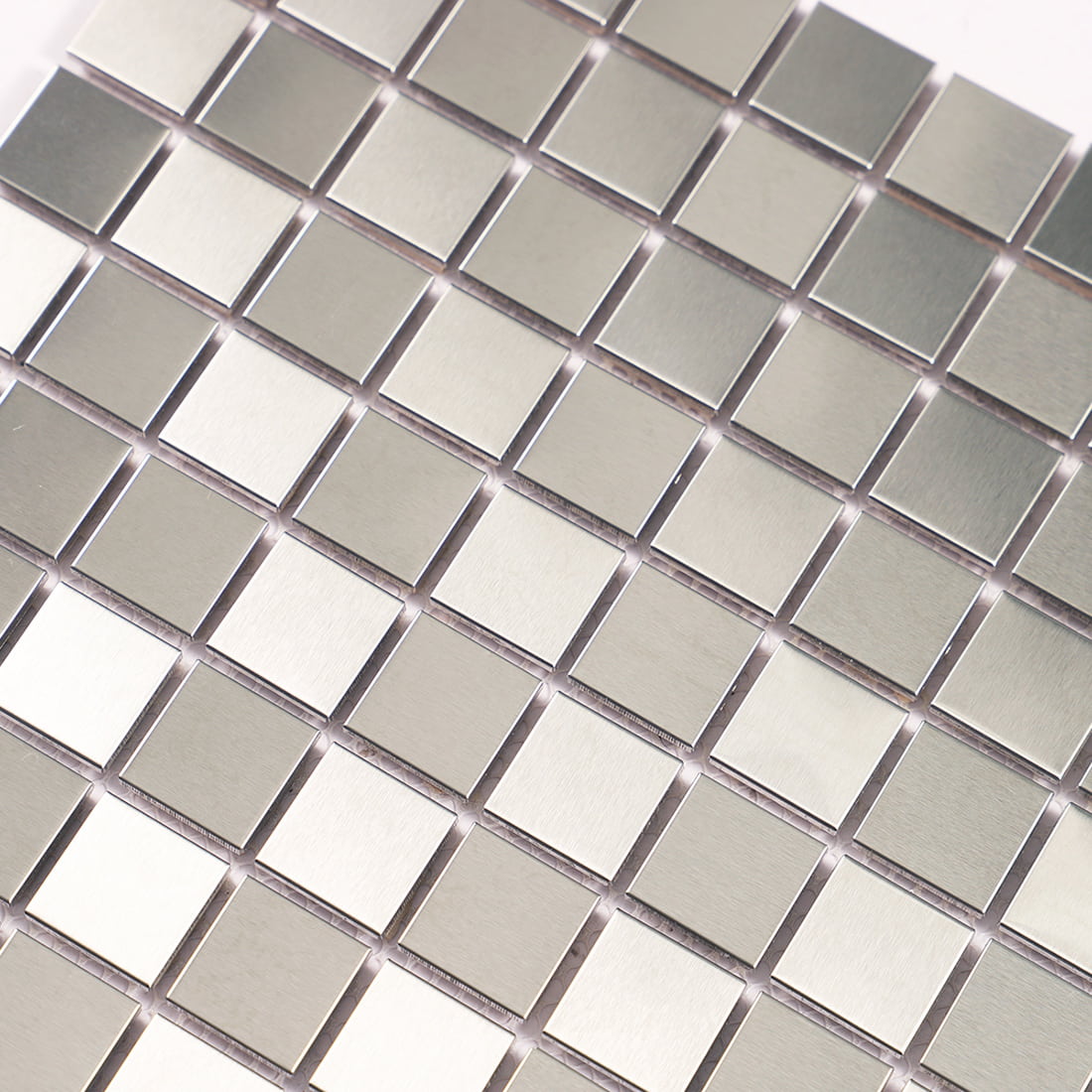 Detail of metallic square mosaic tiles showing surface light reflection.