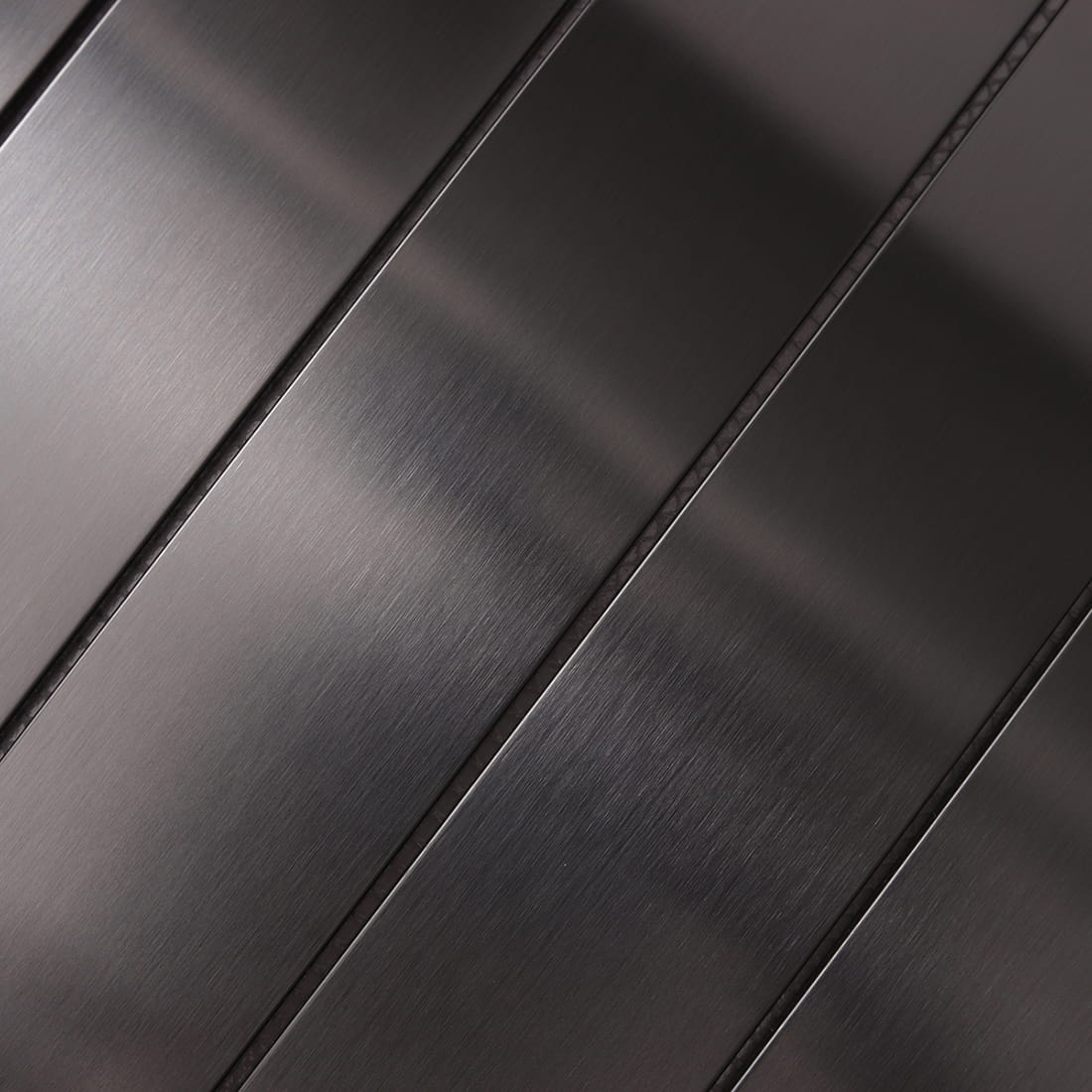 Detailed shot of the grain on black brushed stainless steel strips.