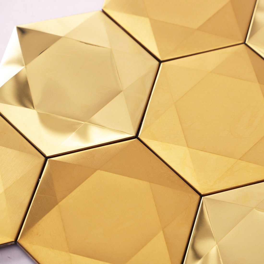 Detailed surface view of 3D gold geometric metal mosaic tiles.