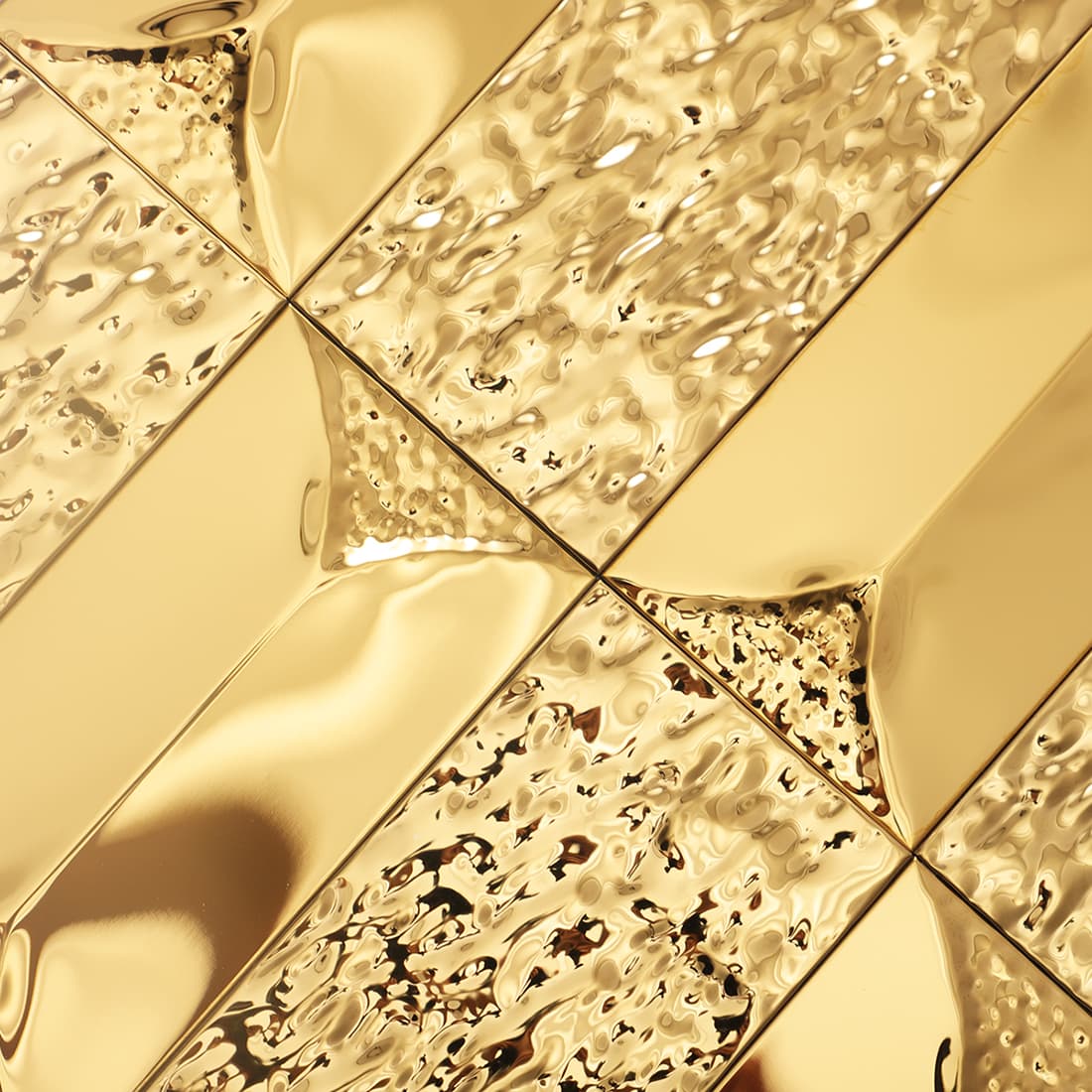 A group of gold wall tiles showing textured and smooth sections from a high, diagonal angle.