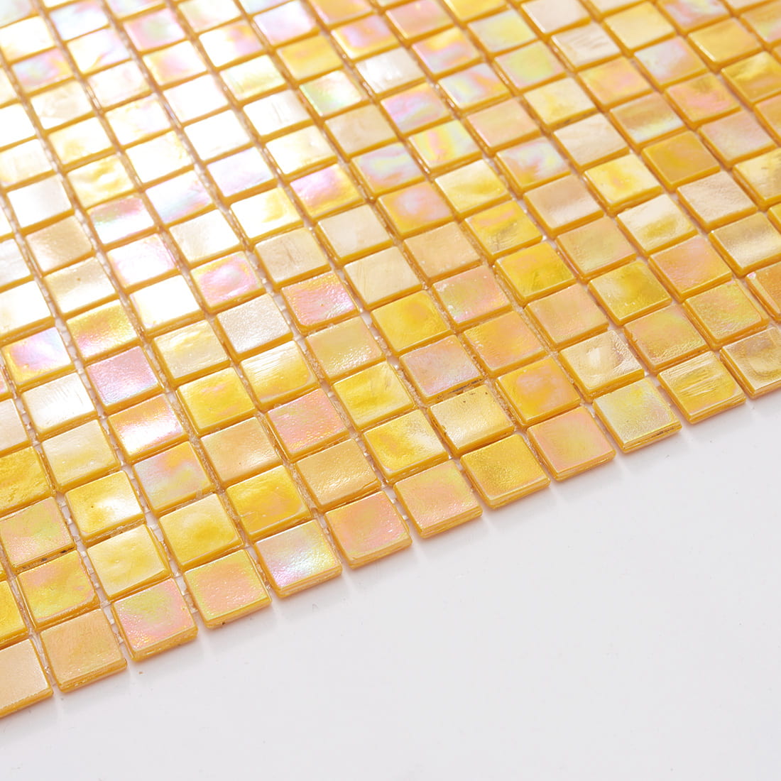 Edge view of iridescent yellow glass mosaic tiles showing thickness and iridescent finish