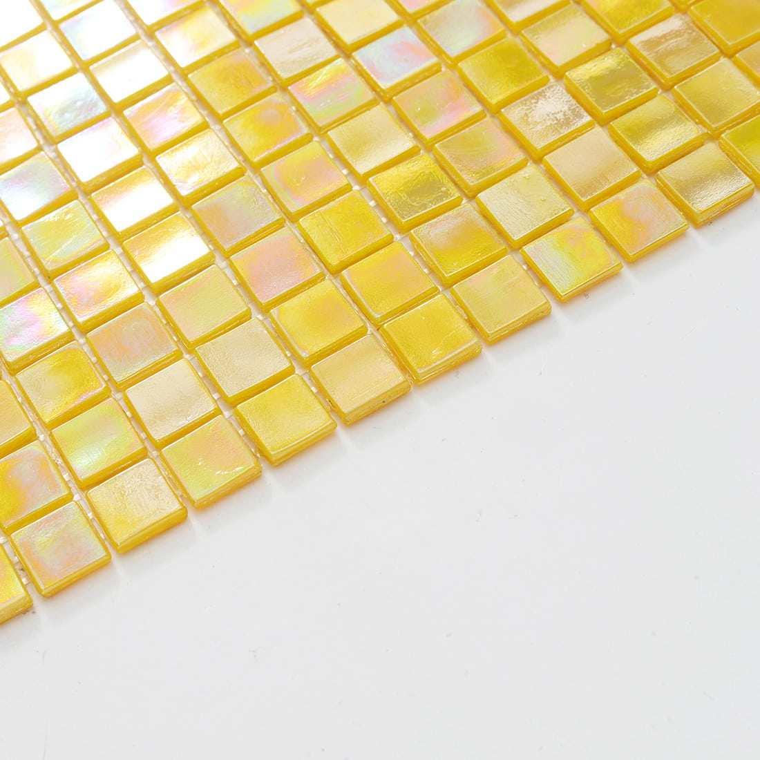 Edge view of opalescent pale yellow glass mosaic tiles showing soft warm yellow tone