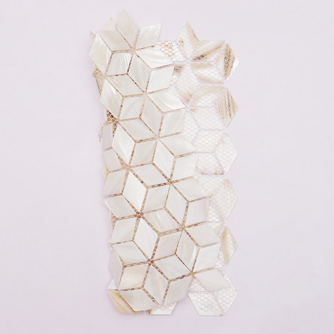 Side view of flexible shell cube mosaic tile with mesh backing