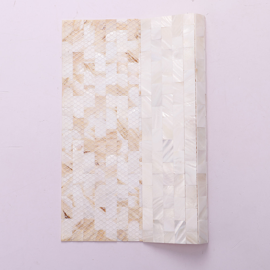 Rolled subway mosaic sheet showing mesh backing and flexibility