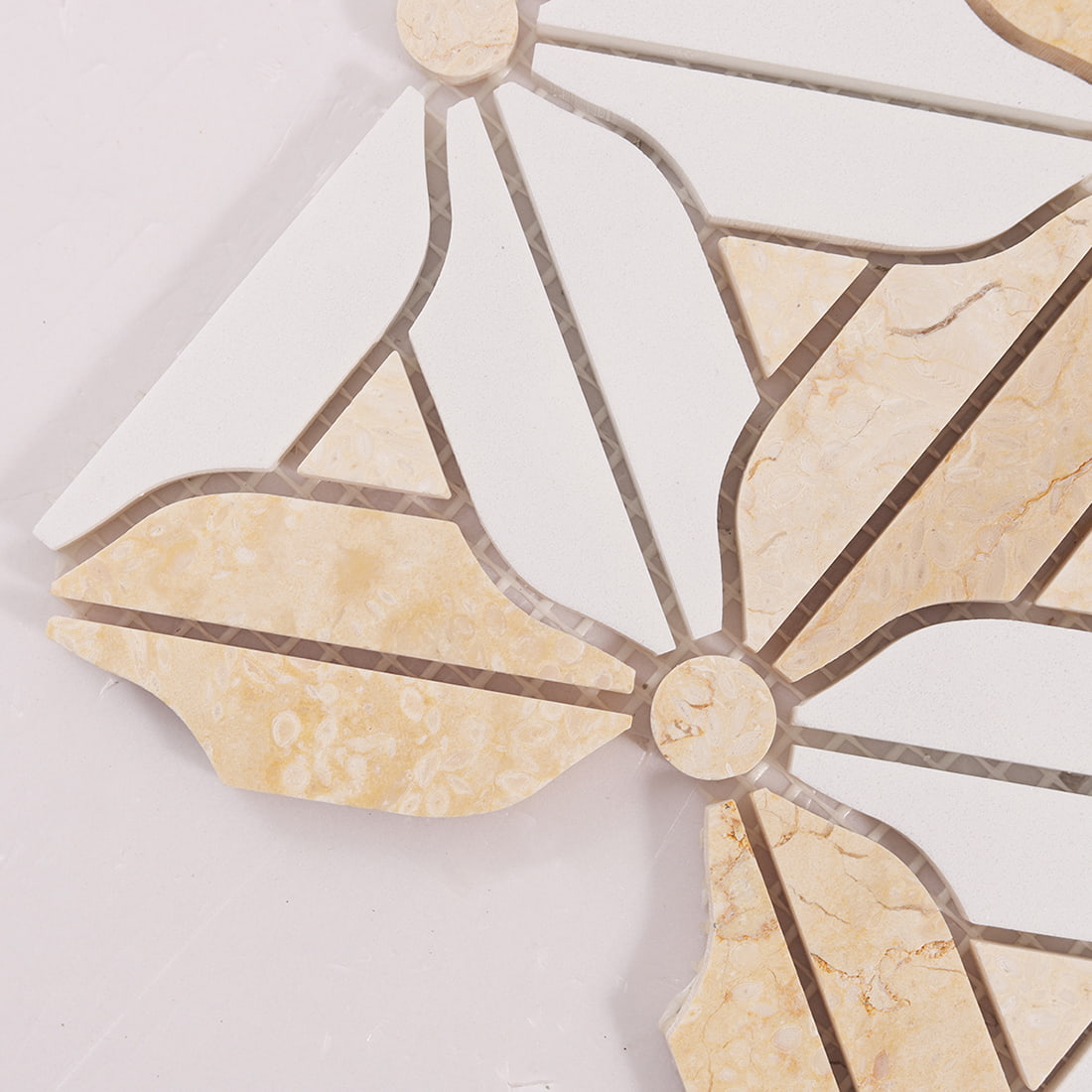 Close up of floral mosaic tile corner showing petal pieces and grout gaps