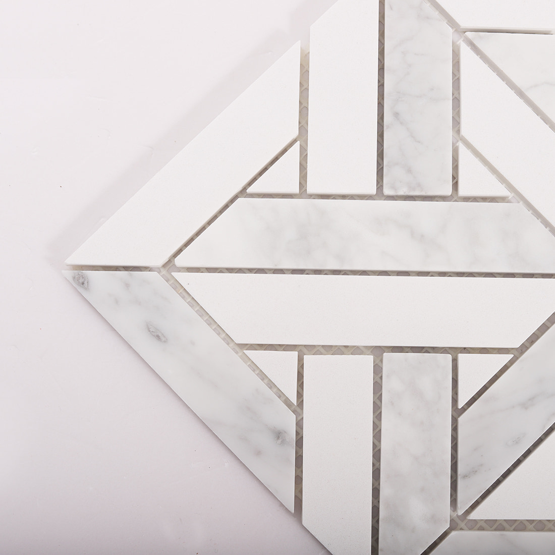 Corner close up of Carrara marble geometric mosaic showing mixed stone pieces