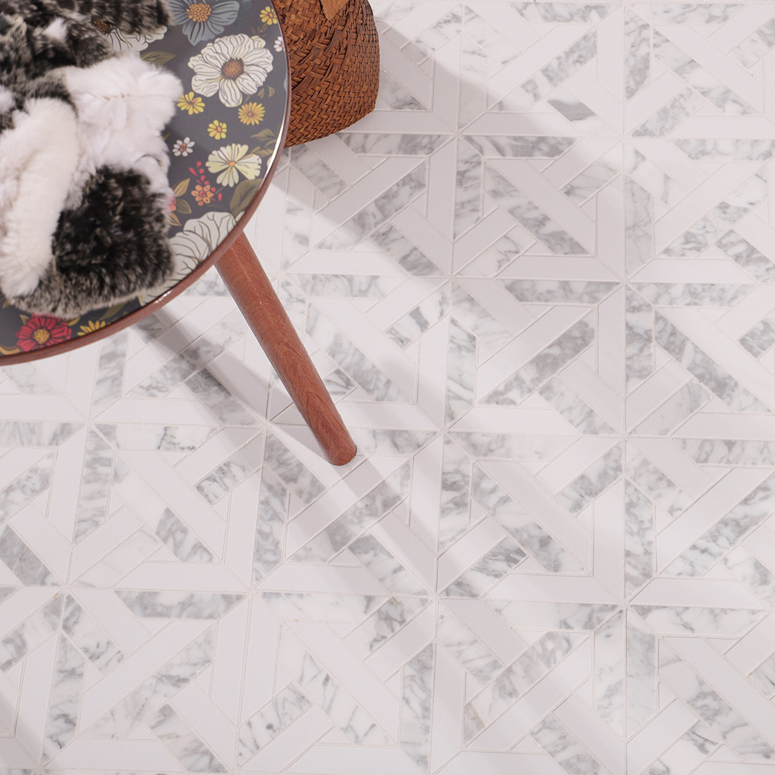 Installed geometric marble mosaic floor with chair leg and decorative accents