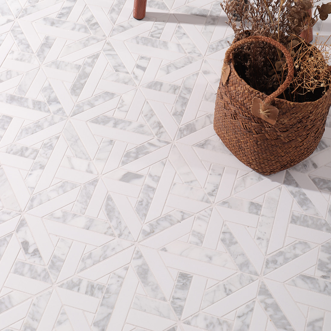 Geometric marble mosaic floor installation with woven basket and dried flowers