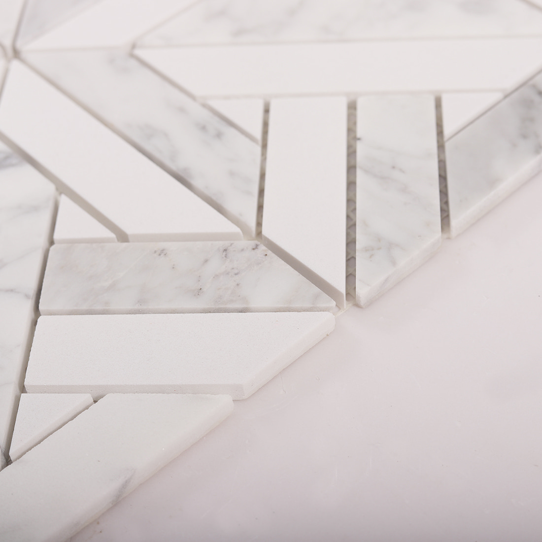 Angled close up showing thickness and polished edges of Carrara marble mosaic