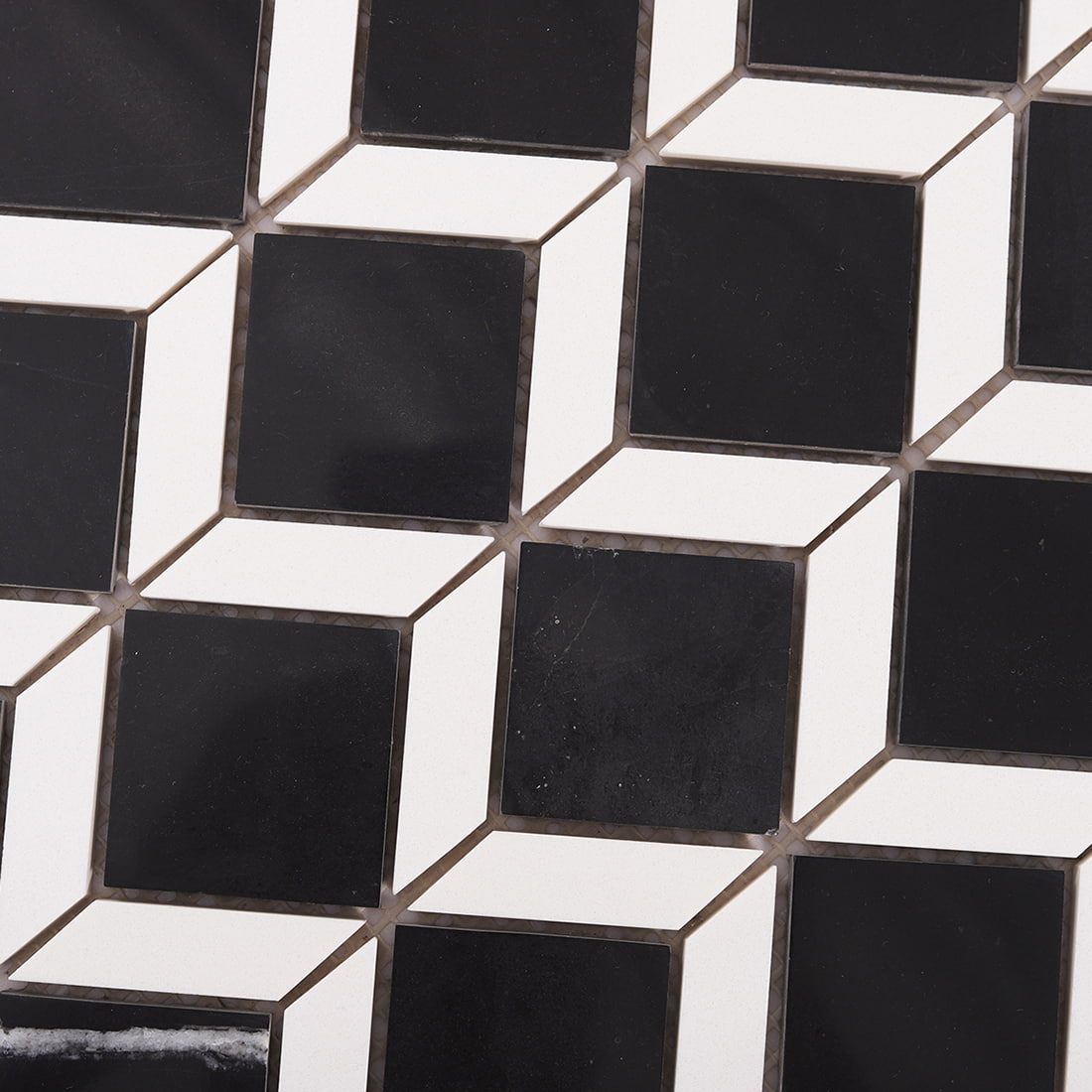 Surface detail of geometric black marble mosaic tile with white stone accents