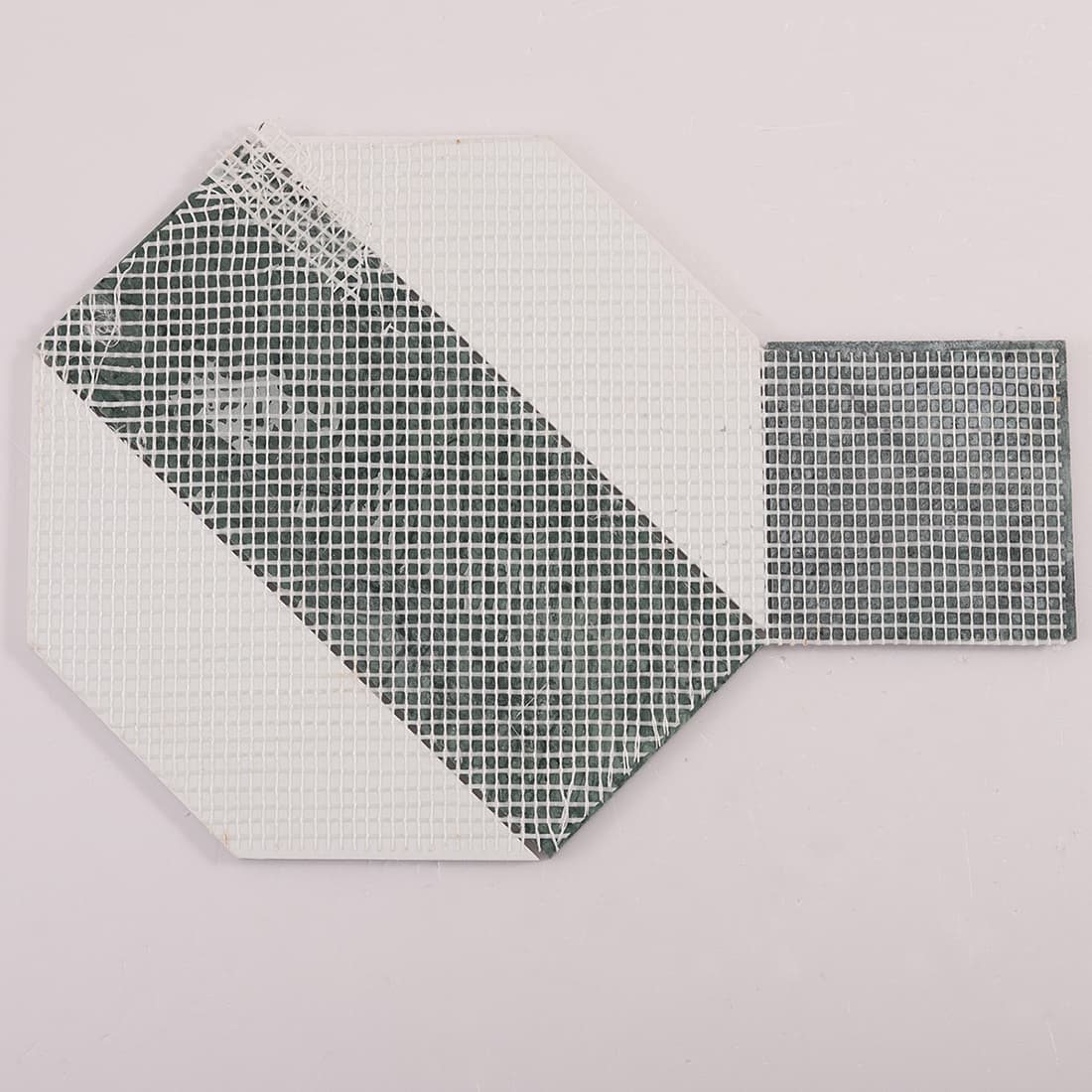 Back view of geometric marble tile showing fiberglass mesh backing