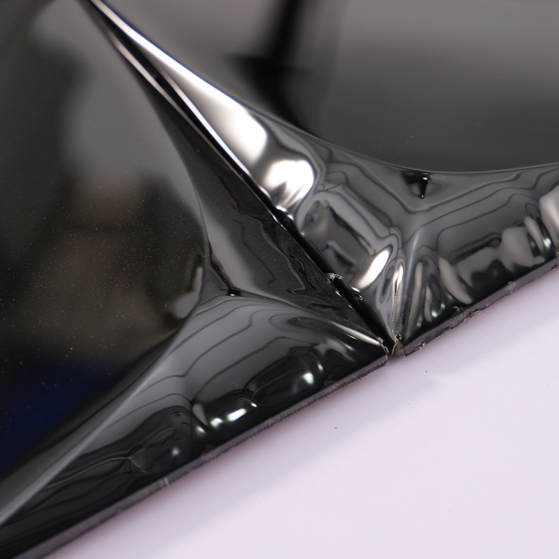 Close-up of raised edges on glossy black 3D stainless steel mosaic tiles