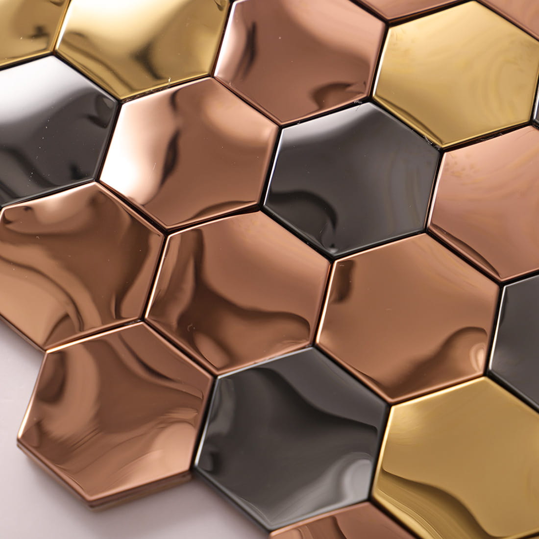 Close up of the smooth and reflective surface of mixed color metal wall tiles.