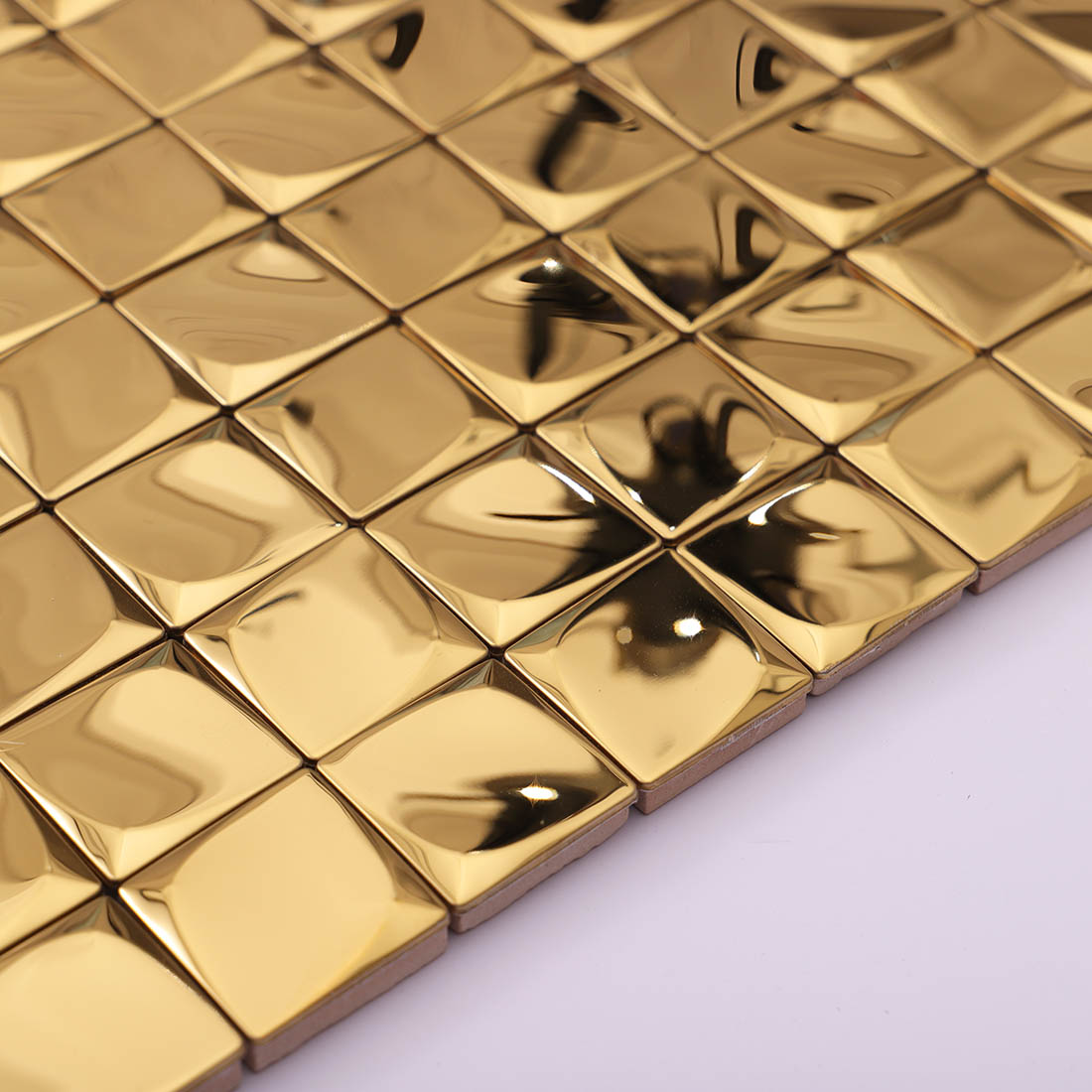 Angled view of gold 3D square metal mosaic tile sheet edge