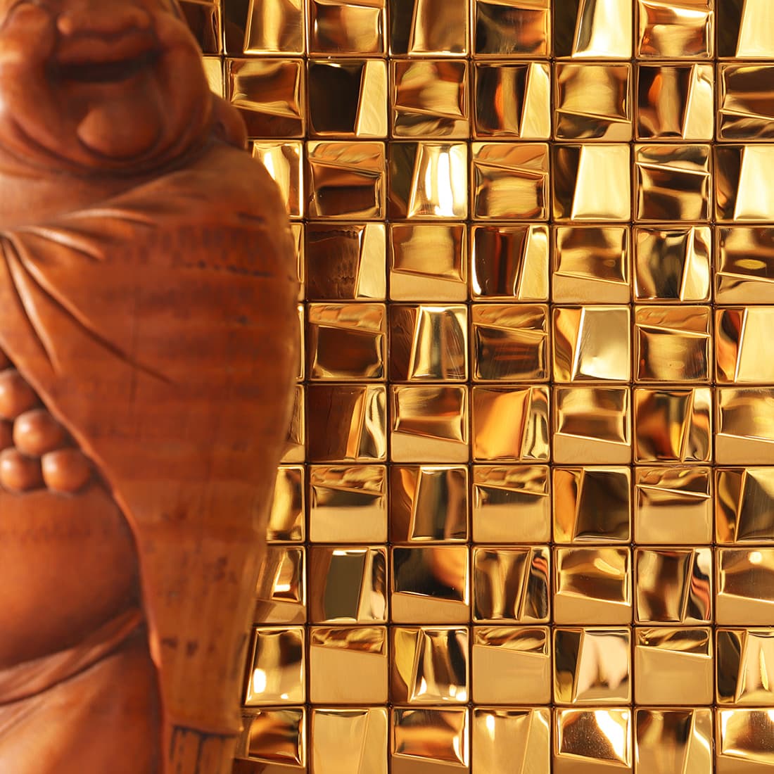 Luxury home interior with a reflective gold 3D square stainless steel mosaic wall.